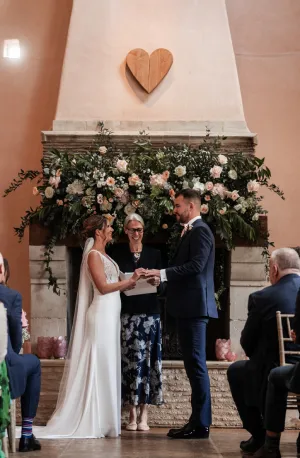 Couple getting married in front of ornamental fireplace