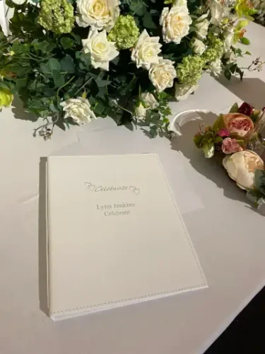 Wedding book on table surrounded by flowers